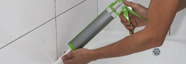 Person versiegelt Fuge mit Kartuschenpistole